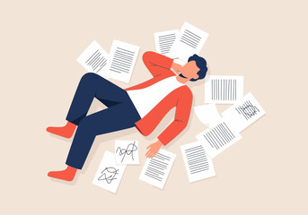 Man lying on floor surrounded by scattered papers and documents.