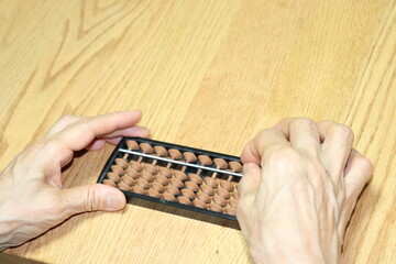 シニア女性が算盤を使っている写真