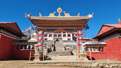 Majestic Buddhist Monastery Entrance with Traditional Architecture and Mountains in the Background