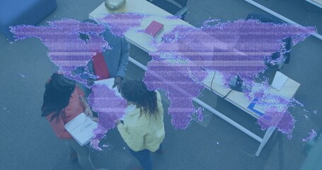 Discussing group wearing jackets in carpeted lounge holding notebook and red folder, map overlay