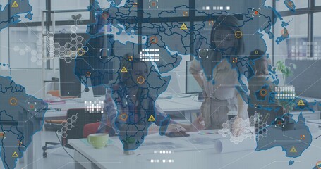 Reviewing team in business attire leaning over table in office with charts, laptop, AR overlay