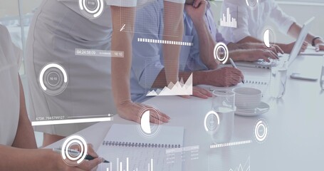 Leaning team in business casual writing in grid notes, typing on laptop, pointing at digital charts © vectorfusionart