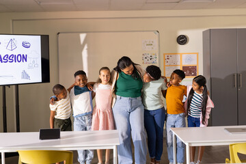 African American teacher with children posing and linking arms in classroom near PASSION display