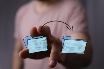 Hand moving files between folders.  Cloud computing, data transfer, sharing, storage concepts.