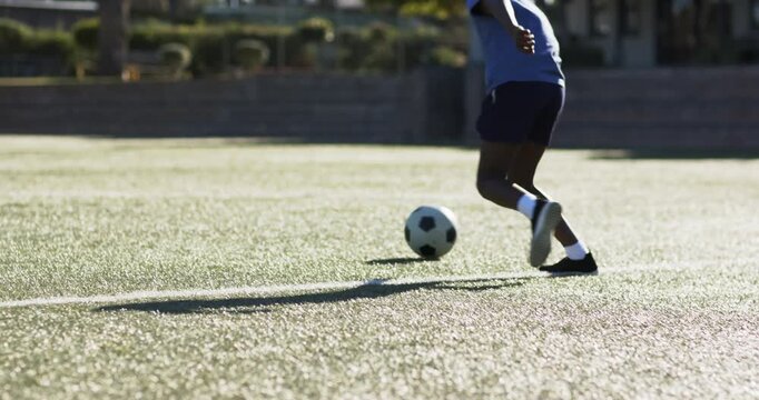 Male player is dribbling ball, causing teammate to receive and advance for shot on sunlit turf