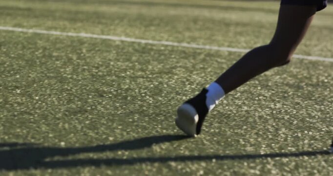 Beige shoes approaching, trying to steal ball; black shoes shielding and rolling to keep possession