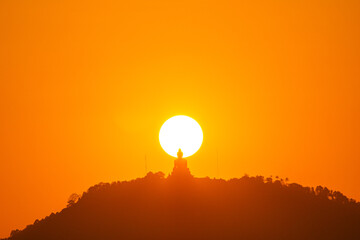 Perched on the mountain peak, the Great Buddha of Phuket becomes one with the sunset  a silhouette framed within the glowing circle of the sun, radiating peace across the island.