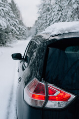 A black car in a snowy forest
