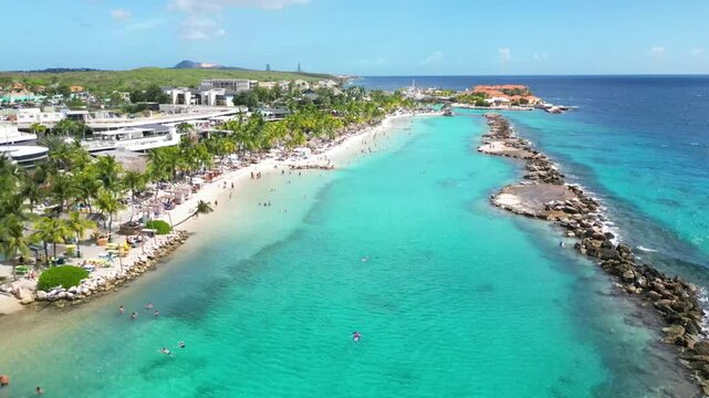 Aerial 4K Drone Footage Flying into Turquoise Water, Swimming People at the Mambo Beach Cura&ccedil;ao, Caribbean