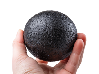 Hand holding a black stress ball stone with firm grip and natural skin texture isolated on transparent background.
