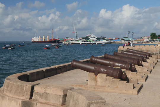 The old cannons on the waterfront of Forodhani park with the ferry and cargo port on backround. Stone Town, Zanzibar, Tanzania