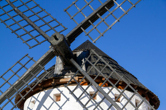 Traditional windmill with wooden sails against clear blue sky