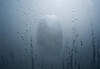 Fingerprint on glass surface showing identity evidence or forensic crime scene investigation concept