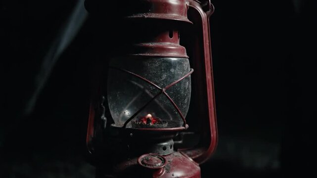 Close-up of red lantern with flickering flame and grimy glass