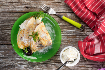 Crepes with ricotta cheese and blackcurrant jam.
