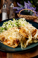 Stuffed pancakes under a cheese blanket.