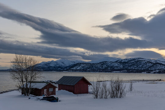 K&uuml;stenlinie mit kleinen H&uuml;tten nahe Gibostad auf der Insel Senja in Norwegen im Winter