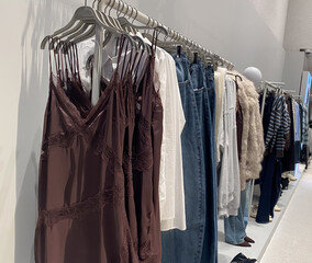 Clothing rack with dresses and jeans in fashion retail store display