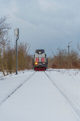 Lokomotywa spalinowa Cargo na zaśnieżonych torach przy Hucie Warszawa, transport kolejowy zimą.