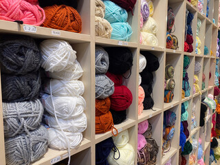 Colorful yarn display with various textures in organized cubby shelves
