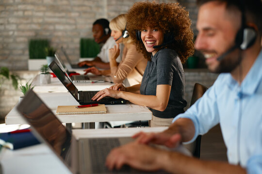 Postrait of cheerful woman with headset in a modern call center