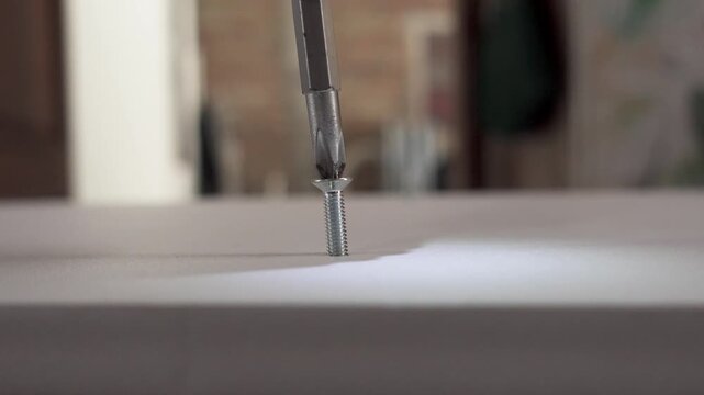 Failed installation of a self-tapping screw into plywood using an electric drill, showing imprecise alignment, DIY mistake, and construction error concept