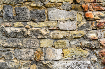 Fototapeta premium A background of old brickwork and unevenly shaped stones. Horizontal color photo