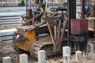 Fototapeta premium Close-up of heavy construction machinery tracks covered in thick mud. Detail of crawler excavator or drilling rig undercarriage on a muddy building site. Industrial texture