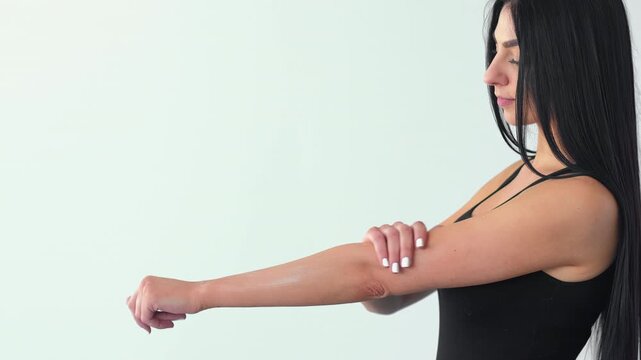 Moisturizing hands. Arm lotion. Woman gently applying balm on palms hydrating elbows shoulders. Everyday treatment isolated on white.