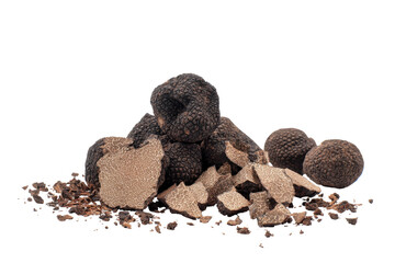 Dark, earthy truffles, whole and sliced, on a bed of soil