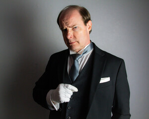Menacing Butler in Formal Attire Staring Daggers. Concept of The Butler Did It.