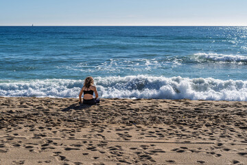 Woman Sitting on Sand Watching Blue Sea Waves