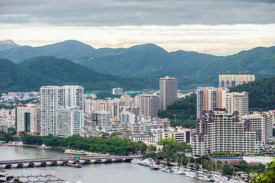 ird eye view of the Sanya city with green mountains in the horizon