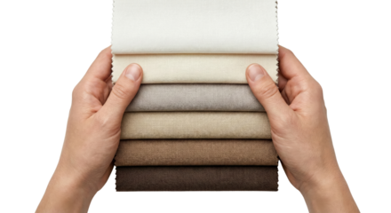 Hands holding swatches of textured fabric samples in neutral tones
