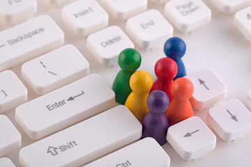 Colorful group of pawn people figures on computer keyboard