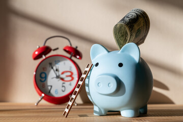 Blue piggy bank with ladder and $1 bill