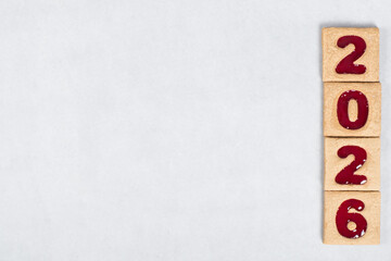 New Year 2026. Holiday Square cookies with red marmalade filling in the shape of the numbers 2026. White background. Copy space