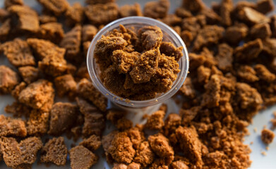 Crushed cookie crumbs in plastic cup with spill