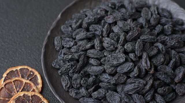 Sweet, dry black or blue raisins made from grapes are a healthy and nutritious food. Black raisins as a food background for your design