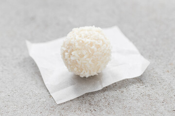 Coconut dessert candy ball. On paper. On a light background. Close-up	
