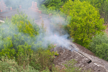 Warehouse fire with smoke and flames from roof