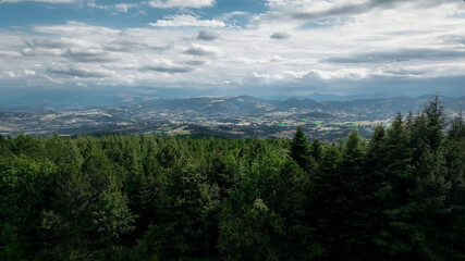 Obraz premium Aerial drone panorama of forested hills and distant valleys in Italy under soft natural light.