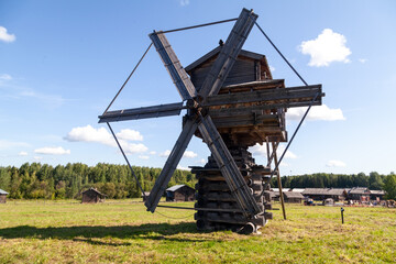 Historic Wooden Windmill with Large Blades under Blue Sky