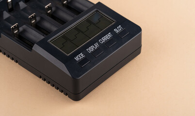 Obraz premium Battery charger with multiple slots and digital display, designed for efficient charging, showcasing modern technology and functionality in a sleek black design