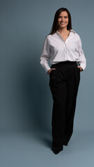 Beautiful, attractive, middle aged woman wearing casual white shirt standing isolated on blue background