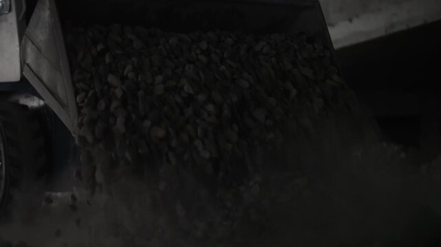 Small loader tractor unloading stone at construction site