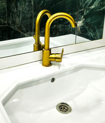 Golden faucet in bathroom sink