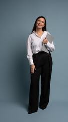 Middle-aged happy businesswoman holding folders on blue