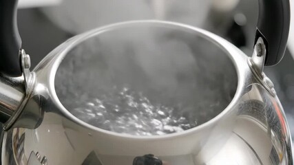 Kettle water at rolling boil 4K video. An intimate close-up capturing vigorous boiling water inside a kettle just before it whistles.
