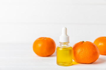 Tangerine essential oil on a wooden table. Bottles of citrus essential oil and sliced ​​fruits....